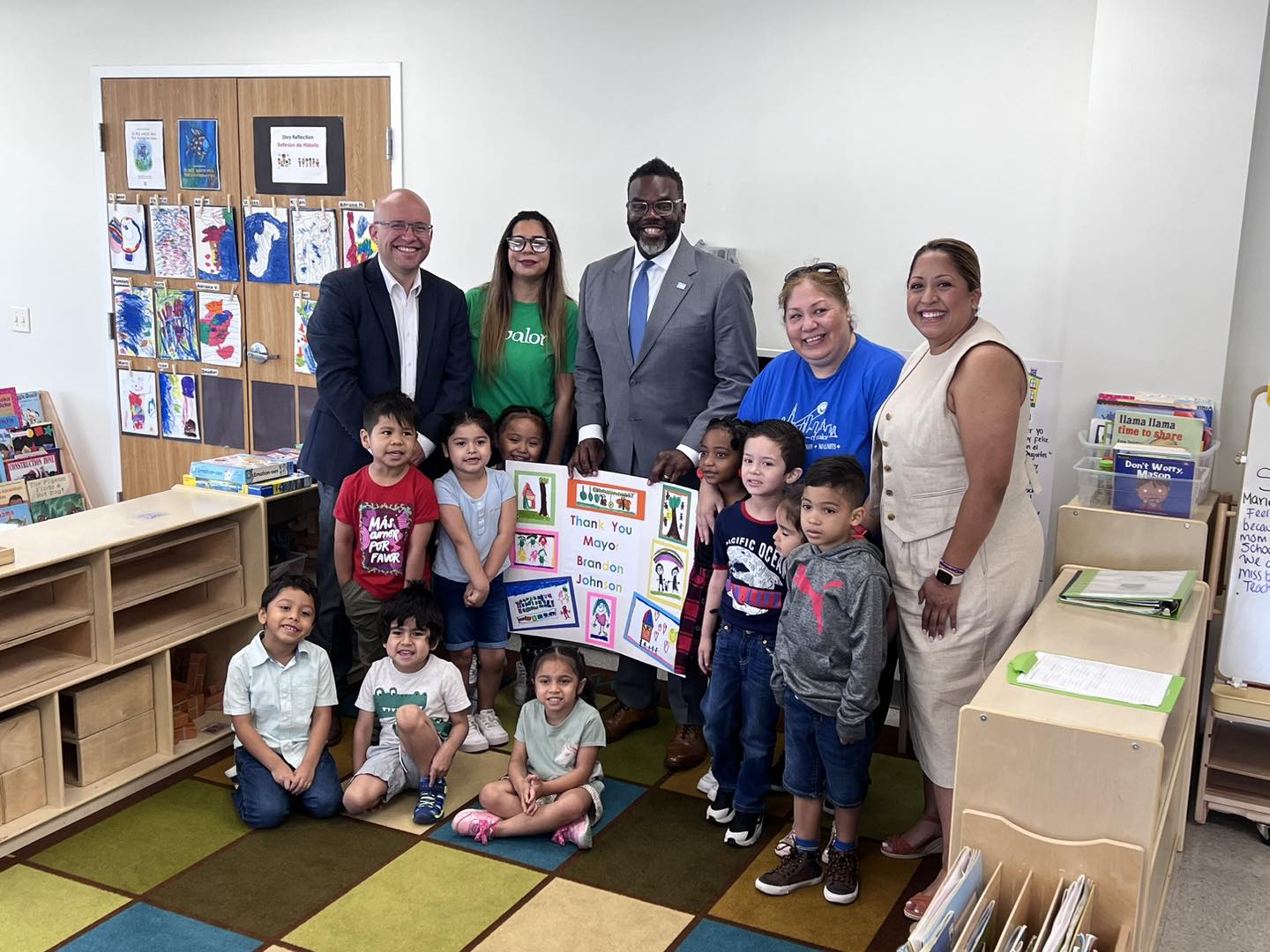 Community leaders and El Valor staff with Head Start children holding a thank-you poster.