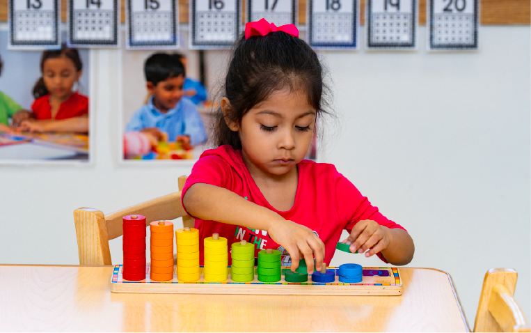 Young girl playing with a colored block stacking system