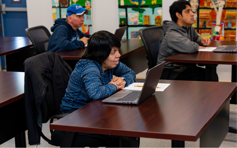 Adult in an El Valor classroom on a computer