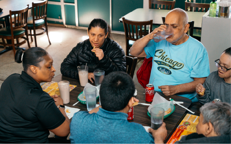 Adults sitting together at a table sharing a meal