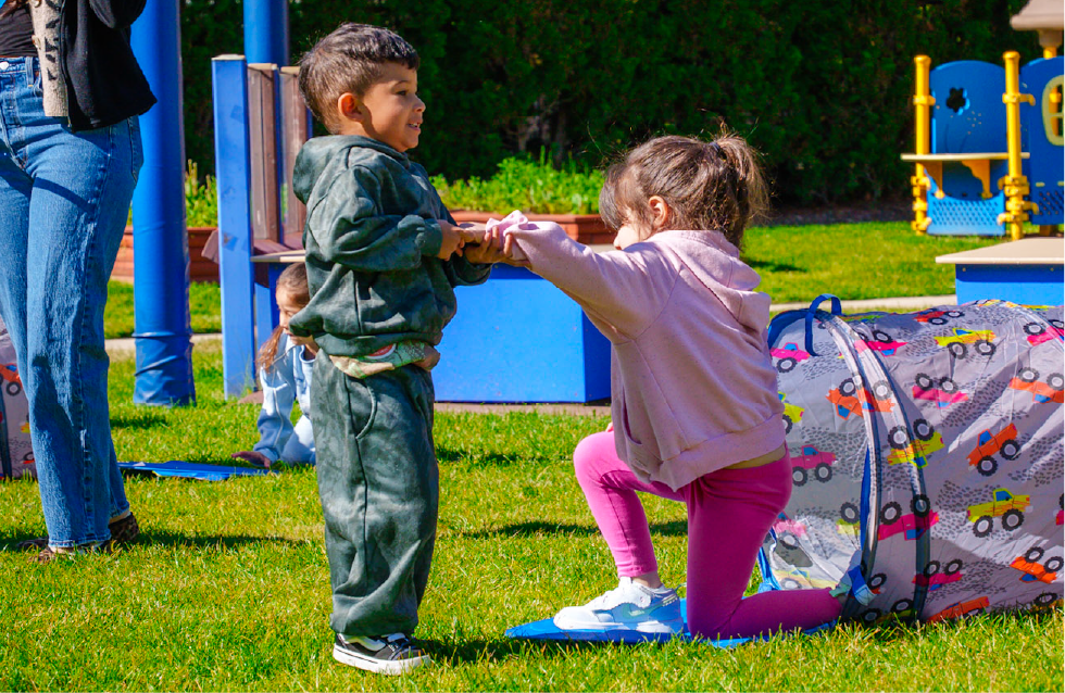 Young boy playing with young girl on a playground