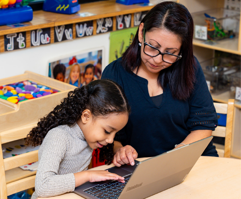 Young girl and El Valor staff learning computer skills