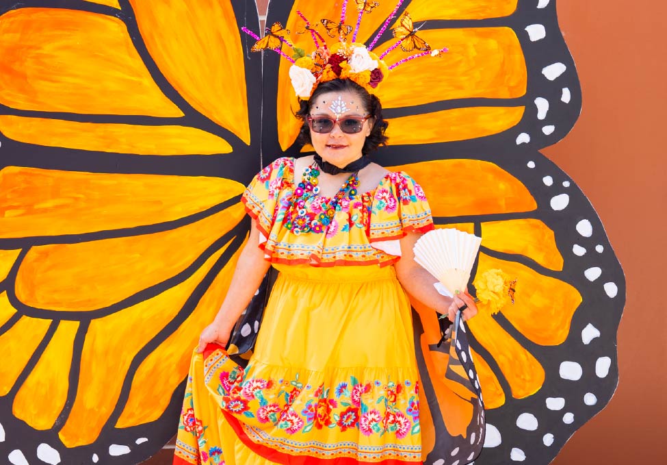 A young girl wearing a yellow folklorico dress.