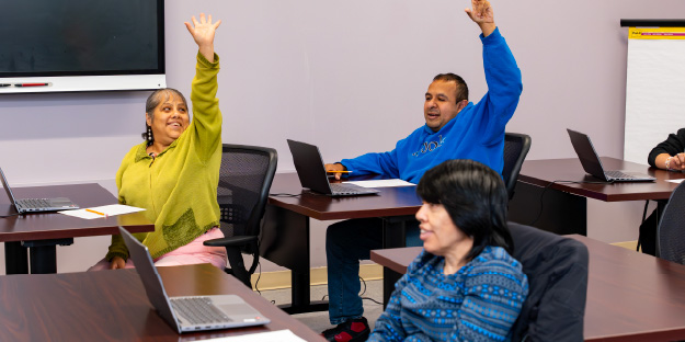 Adults raising their hands in an El Valor