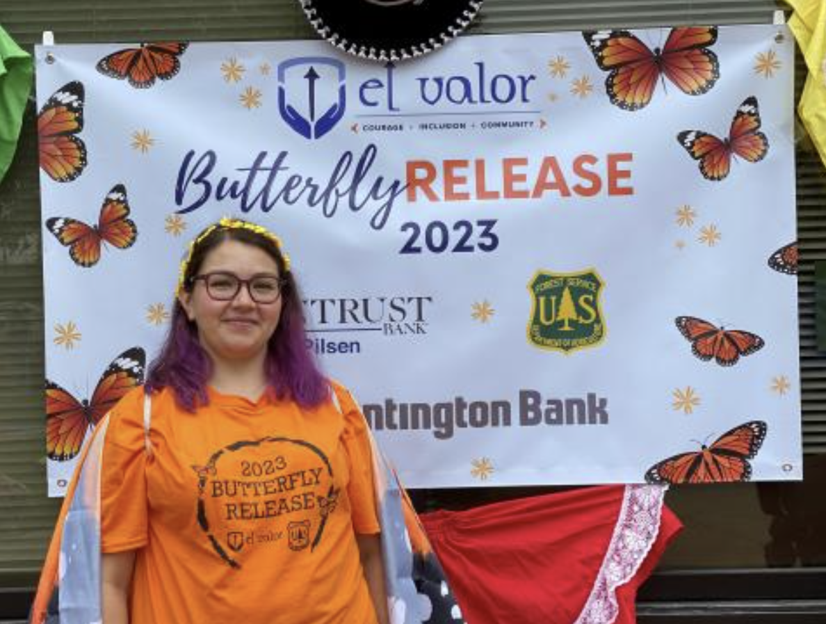 A person stands beside a Butterfly Release 2023 banner.